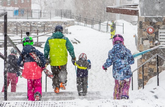 family of skiers walking down stairs