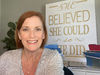 Melanie Cameron in front of "She Believe She Could So She Did" sign.