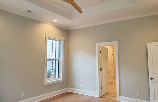 A primary bedroom suite with a trey ceiling and attached full bathroom.