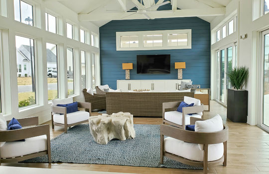 The sitting area of Waterstone's clubhouse, which has exposed beams and walls of windows.