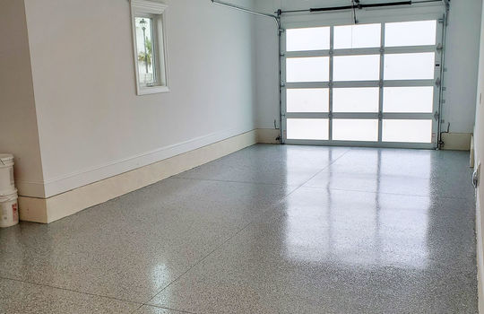 A luxury garage with a finished floor and door opener.