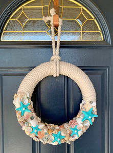 Nautical rope wreath with seashells and blue starfish.