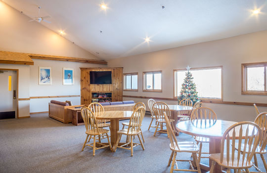 Common room with couches, tables, and TV at Sunrise Condo