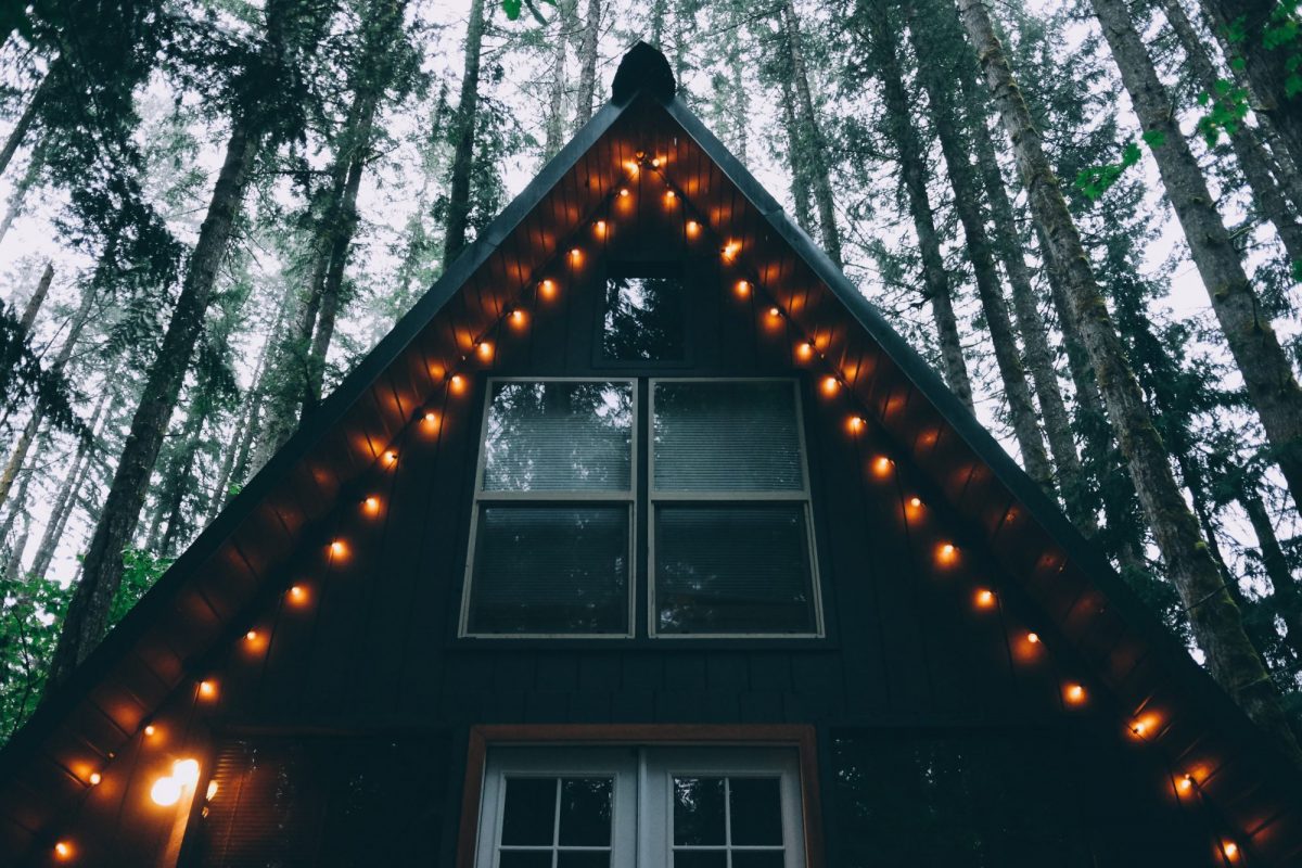 A-frame ski home in the woods with lights on the roof
