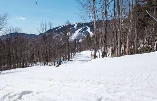 Skier going down trail view from lot