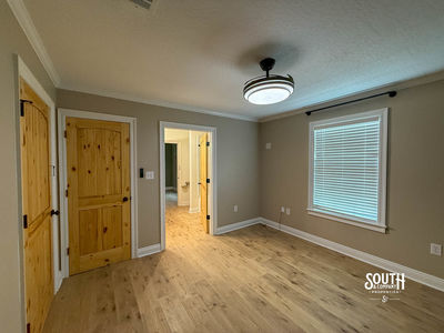 Additional view of bedroom showing natural-wood doors and access toward a bathroom